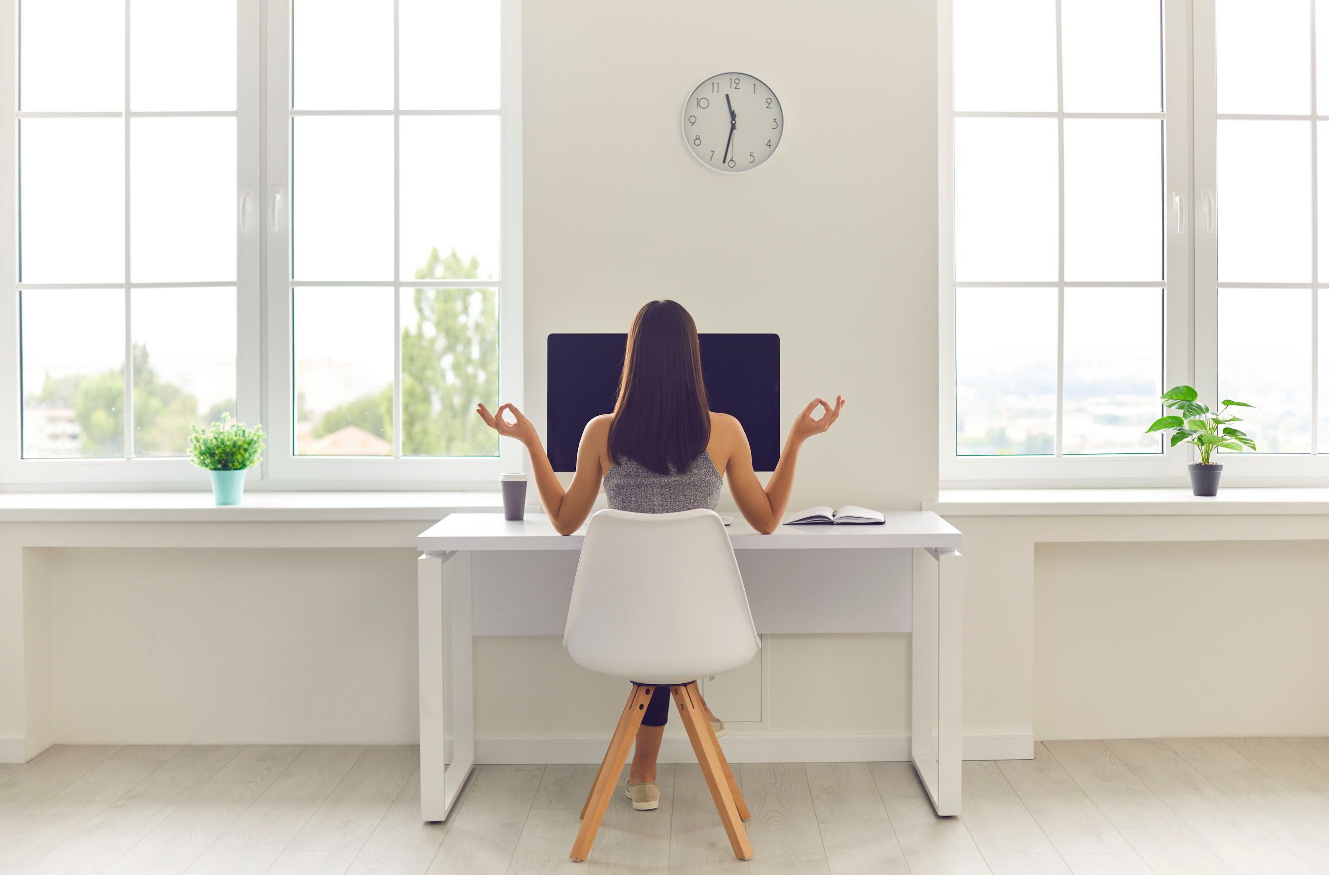 Woman Taking Break from Work and Meditating Sitting at Office Table with Computer and Coffee
